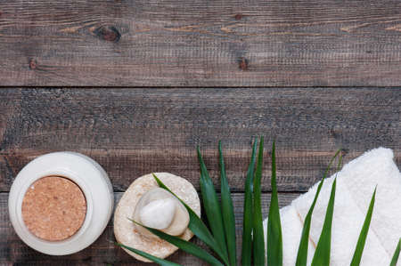 Brown wooden background with terry towel, palm leaf and stones. Copy spaceの写真素材