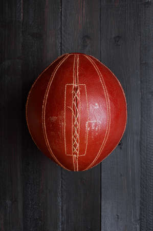 Vintage brown oval boll on the black wooden floorの写真素材