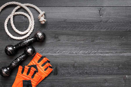 Sport glove, small vintage dumbbell and rope. Black background with copy spaceの写真素材
