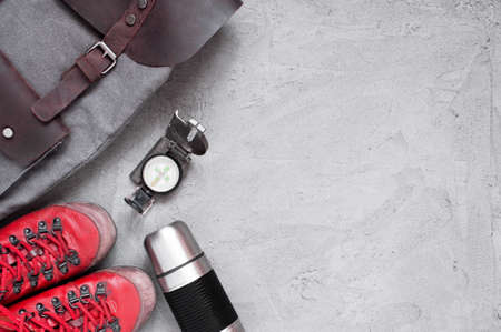 Background with old red shoes, backpack and compass on the light-gray cement surface, copy spaceの写真素材