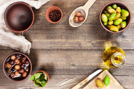 Textured background with salted olives of several varieties and kitchen utensils, copy spaceの写真素材