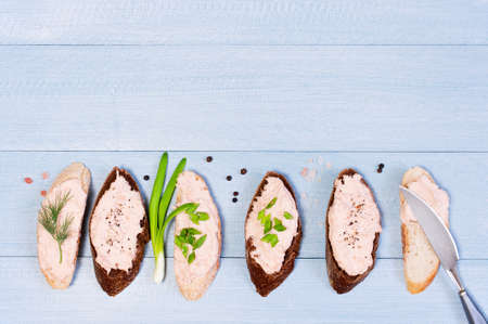 Background with salmon pate on pieces of various bread, blue wooden table. Top view.の写真素材