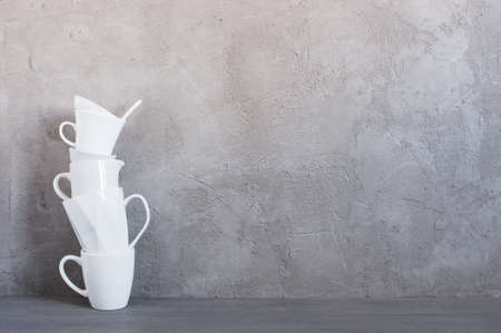 White crockery on the table against the textured grey wall, background with copy spaceの写真素材