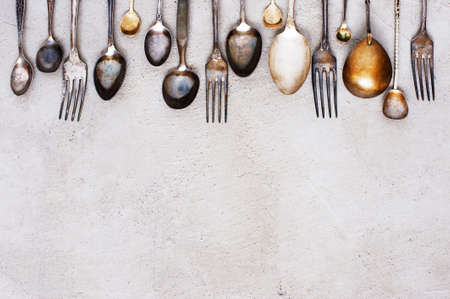 Background with vintage silverware on the textured grey table, top view の写真素材