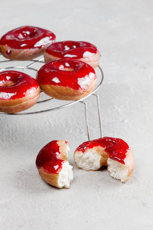 Fresh homemade donuts with red glaze on the metal greedの写真素材
