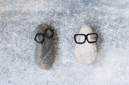 Background with various funny characters of stones on the grey textured surface, copy space 