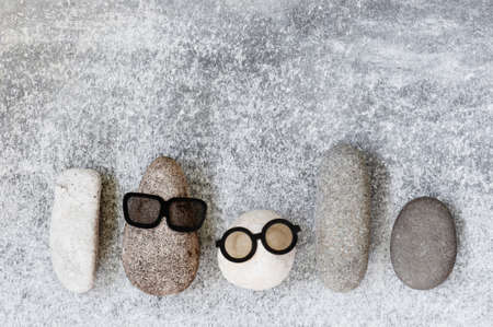 Background with various funny characters of stones on the grey textured surface, copy spaceの写真素材
