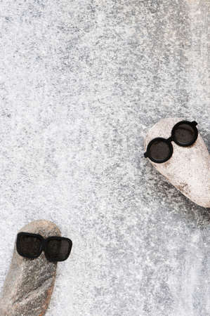 Background with two funny characters of stones on the grey textured surface, copy space の写真素材