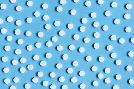 Blue textured background with white pills, top viewの写真素材