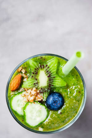 Glass of green healthy smoothie decorate with ingredients, top view, copy spaceの写真素材