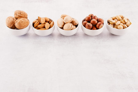Background with various nuts in the small plates, copy spaceの写真素材