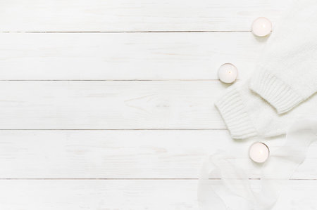 Tender white wooden winter background with burning candles, copy space