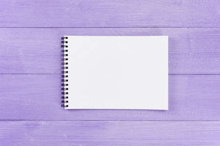 Blank sheet of opened notepad on the violet textured wooden table, copy spaceの写真素材