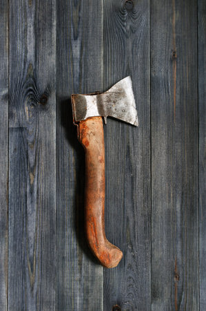Old ax on the dark wooden table,top view