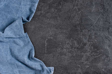 Background with blue denim napkin on the dark gray textured table, copy spaceの写真素材