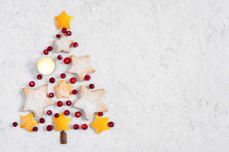 Christmas tree made of cookies, berries and orange pill, festive composition, copy spaceの写真素材