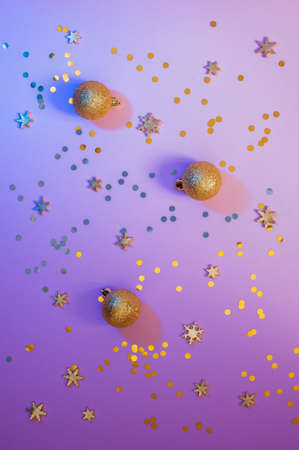 Festive violet background with golden confetti and snow flakes, top viewの写真素材