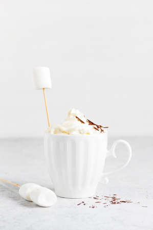 Cup of hot drink with whipped cream, marshmallow and chocolate, white background の写真素材