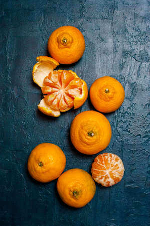 Fresh ripe mandarins on the textured navy blue table, top viewの写真素材
