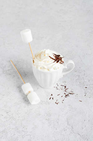 Cup of hot drink with whipped cream, marshmallow and chocolate, white backgroundの写真素材