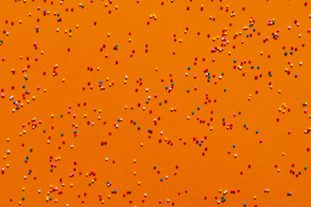 Bright orange festive background with small sweet balls