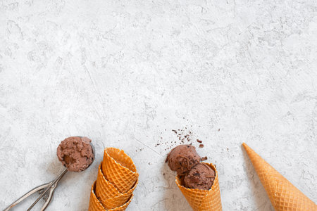 Background with chocolate ice cream, waffle cones and scoop, copy space