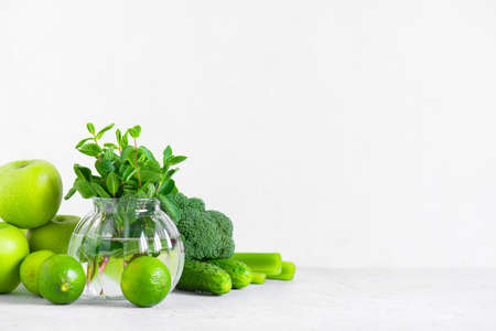 Background with fresh green vegetables and fruits for healthy eating, ingredients for smoothies or salad on whiteの写真素材