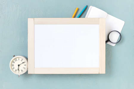 Blue background with marker board, alarm clock and school supplies. Copy space の写真素材