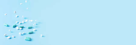 Blue banner with falling pills, concept of medication treatmentの写真素材