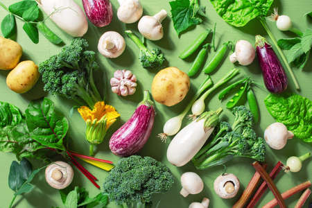 Fresh organic vegetables on the green table, raw ingredients for cooking, concept of healthy eating, top viewの写真素材