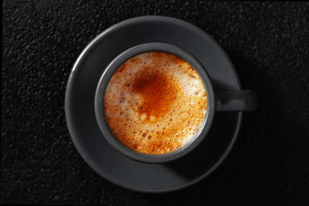 The cup of espresso coffee on black table, closeup overhead viewの写真素材
