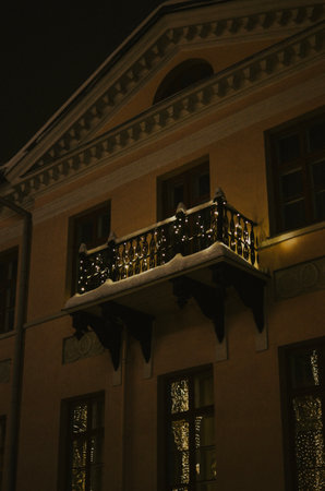 brightly decorated balcony with yellow garlands in the city center for Christmas at nightの写真素材