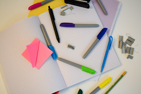 scribbled notebooks and pens with colored felt-tip pens for studying at school on a white desk