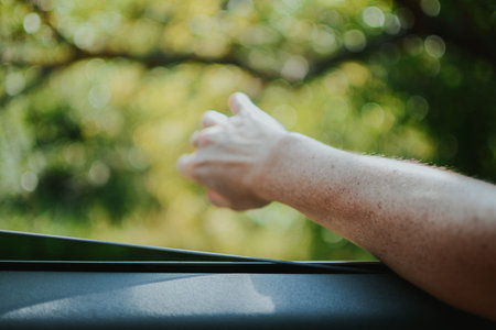a girl stuck her hand with a manicure out the open window during a trip in the forest