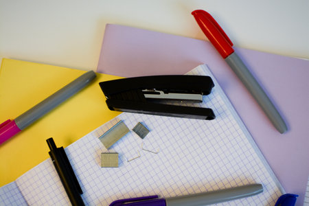 scribbled notebooks and pens with colored felt-tip pens and a stapler for studying at schoolの写真素材