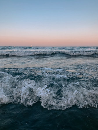 sea at sunset with strong waves on the beach on a summer vacation dayの写真素材
