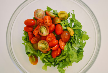 salad bowl with cherry tomatoes and lettuce on a white backgroundの写真素材