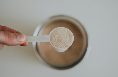 measuring cup with vanilla protein and a shake next to it for making a shake