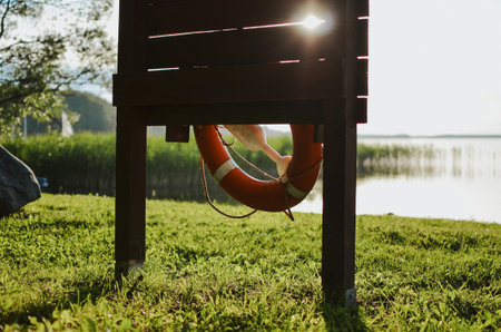 hanging red lifebuoy on the beach of the lake to help drowning peopleの写真素材