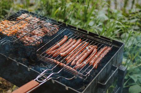 bbq meat and sausages with smoke on a grill in nature on a lake in summer in Estonia