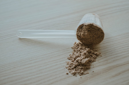 measuring cup with chocolate protein for training athlete