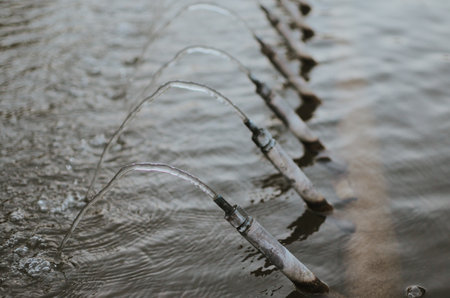 faucets in a street fountain from which water flowsの写真素材