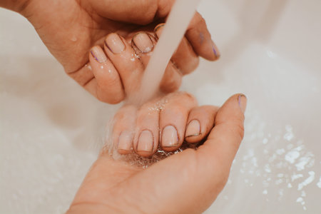 Hands of a girl after gardening with dirt under her nails who washes her hands with soapの写真素材