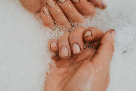 Hands of a girl after gardening with dirt under her nails who washes her hands with soap