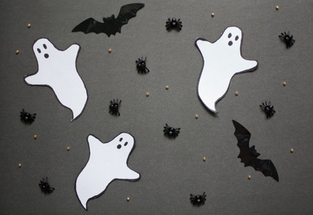 Halloween composition with spiders, bats and ghosts on a black background. Holiday illustration.
