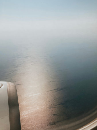view from airplane window with sky and sea during flight on vacation