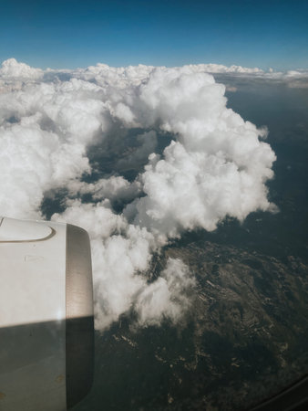 view from airplane window with sky and clouds during flight on vacation