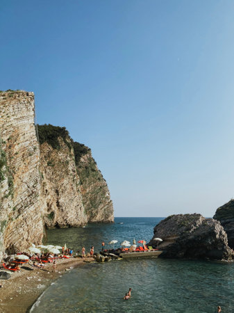 High cliff with trees right next to the Adriatic sea beach in Montenegroの写真素材
