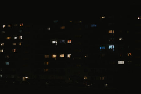 residential apartment building at night with different lights from windows and balconies