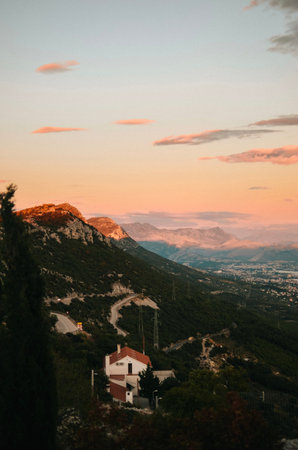 view from the top of the mountain by the Adriatic sea on the forest with a house and a path for cars